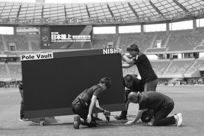 大会運営で表示装置を設置するスタッフ