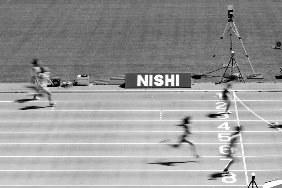NISHIの表示装置とトラックを走る選手たち